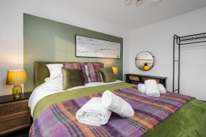 a bedroom with a bed with towels on it at Leyland House - Private Parking Free Wi-Fi Garden in Leyland