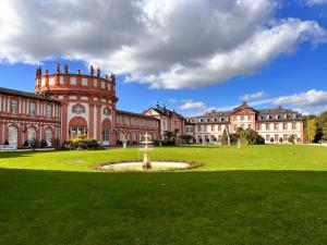 ein großes Gebäude mit einem Brunnen in der Mitte eines Feldes in der Unterkunft Apartment am Schloss-Park Wiesbaden Biebrich am Rhein in Wiesbaden