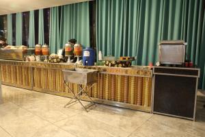 a buffet line in a room with a table and a podium at Raghav inn in Karnal