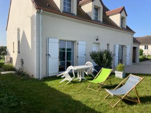 a yard with two lawn chairs and a table at Chambre d’hôte Chancelier Guerin in Mont-lʼEvêque