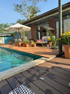 a house with a swimming pool next to a house at Lọ Lem home stay in Vĩnh Long