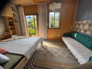 a bedroom with two beds and a couch and a window at Lọ Lem home stay in Vĩnh Long