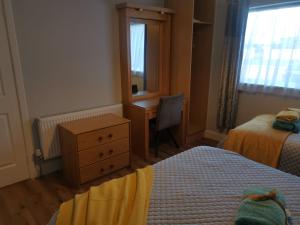 1 dormitorio con 2 camas, escritorio y tocador en Tranquil unit close to Kells, en Kilkenny