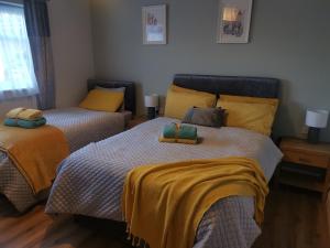 a bedroom with two beds with yellow and blue sheets at Tranquil unit close to Kells in Kilkenny