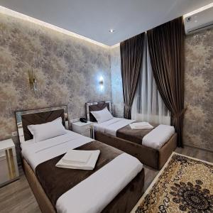 um quarto de hotel com duas camas em The Afrosiyob Ok em Samarkand