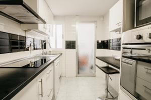 a white kitchen with a sink and a shower at tuGuest Maria Luisa Apartment in Granada