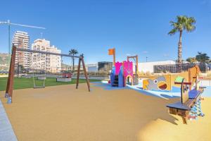 een park met een speeltuin met een glijbaan en schommels bij Alexia 2 Calpe in Calpe