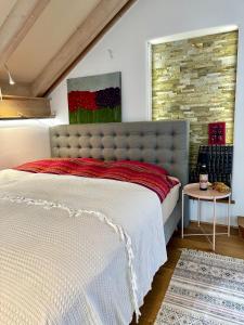 een slaapkamer met een groot bed en een bakstenen muur bij La Vie en rose 
