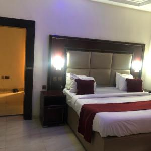um quarto com uma cama grande e uma grande cabeceira. em MCLORRETS SUITES em Enugu