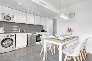a white kitchen with a table and chairs in it at Alexia 2 Calpe in Calpe