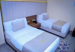 Habitación de hotel con 2 camas y mesa en Jees Hotel, en Hargeysa