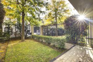 una valla de hierro forjado con un árbol en un patio en 328 Suite Nathaniel - Superb apartment in Paris, en Saint-Mandé