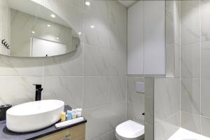a white bathroom with a sink and a mirror at 328 Suite Nathaniel - Superb apartment in Paris in Saint-Mandé