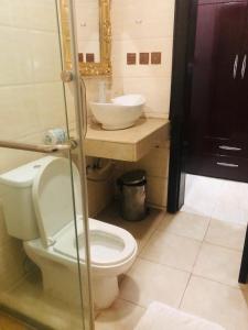 a bathroom with a toilet and a sink at MCLORRETS SUITES in Enugu