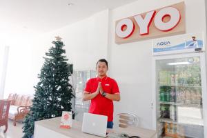 Ein Mann steht in einem Laden mit einem XO-Weihnachtsbaum in der Unterkunft OYO 1194 Villa Bukit Panderman Residence in Tlekung