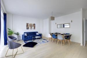 a living room with a blue couch and a table at 328 Suite Nathaniel - Superb apartment in Paris in Saint-Mandé