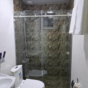 ein Bad mit einer Dusche, einem WC und einem Waschbecken in der Unterkunft The Afrosiyob Ok in Samarkand