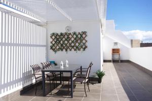 ein Esszimmer mit einem Tisch und Stühlen auf einer Terrasse in der Unterkunft Apartamentos Las Majoreras 1 y 2 dormitorios in Las Majoreras