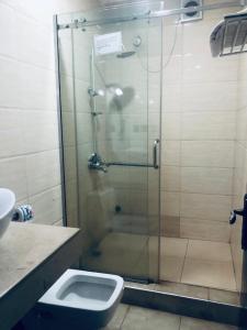 a bathroom with a shower with a toilet and a sink at MCLORRETS SUITES in Enugu
