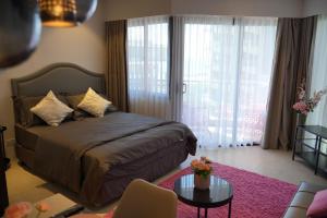 1 dormitorio con 1 cama y 1 mesa en una habitación en Dominiks Modern pink Studio Balcony & Ocean View Balcony 11 Floor Fast-Wifi at Tambuli Resort en Maribago