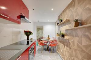 een keuken met een kleine tafel en rode stoelen bij 812 Suite Besty Paris - Superb apartment in Paris in Asnières-sur-Seine