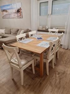 einen Holztisch und Stühle im Wohnzimmer in der Unterkunft Ferienwohnung Nordseetraum in Hage