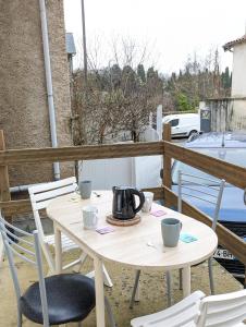 uma chaleira de chá sentada numa mesa numa varanda em Pari57bis - T2 meublés entre centre ville et Futuroscope à 15min - CHU - CCI à 5 min em Poitiers