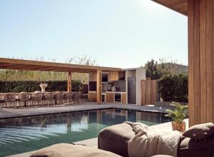 une maison avec une piscine à côté d'une cuisine dans l'établissement ÒLA Exclusive Residence, with Pool & Beach Access, By ThinkVilla, à Tsilivi
