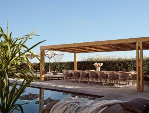 une terrasse avec des chaises, une table et une piscine dans l'établissement ÒLA Exclusive Residence, with Pool & Beach Access, By ThinkVilla, à Tsilivi