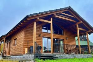a log cabin with a large porch and large windows at Chata u Hrušků 100m od sjezdovky in Oravská Lesná