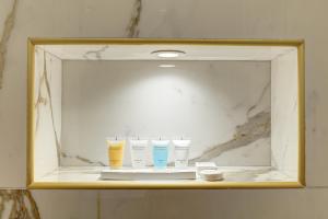 un espejo en un baño con tres tazas en un estante en 327 Suite Le Marais - Superb apartment in Paris, en París