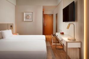 a hotel room with two beds and a tv at Dom Jose Beach Hotel (Plus) in Quarteira