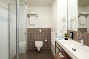 a bathroom with a toilet and a sink and a shower at Dom Jose Beach Hotel (Plus) in Quarteira