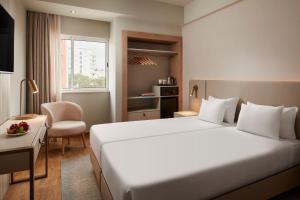 a hotel room with a large bed and a chair at Dom Jose Beach Hotel (Plus) in Quarteira