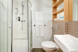 a bathroom with a shower and a toilet and a sink at Dom Jose Beach Hotel (Plus) in Quarteira