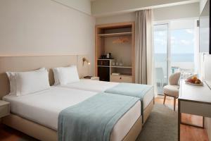 a hotel room with a bed and a view of the ocean at Dom Jose Beach Hotel (Plus) in Quarteira
