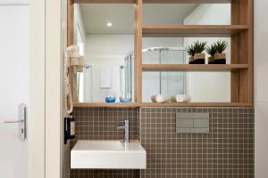a bathroom with a sink and a mirror at Dom Jose Beach Hotel (Plus) in Quarteira