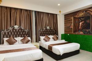 a bedroom with two beds and a horse picture on the wall at Seeds Hotel Shah Alam Section 19 in Shah Alam
