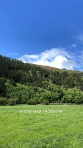 a field of green grass with a mountain in the background at Chalet en entorno rural a 15 minutos de la playa. in Lamiña