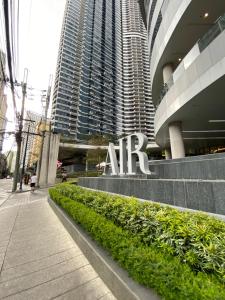 a sign in front of a building with tall buildings at Frost at Air Residences Makati in Manila