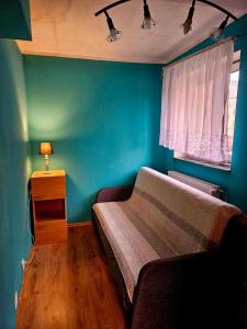 a bedroom with a bed and a blue wall at Spokojne i miłe miejsce na Mazurach in Kętrzyn