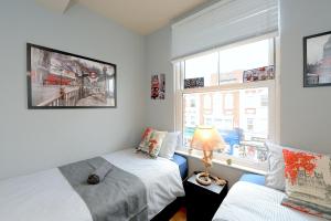 1 dormitorio con 2 camas y ventana en 2 BEDROOM FLAT in WOOD GREEN PICCADILLY LINE en Londres