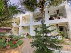 ein Gebäude mit Palmen davor in der Unterkunft Melba Beach Resort By Maitree in Arambol