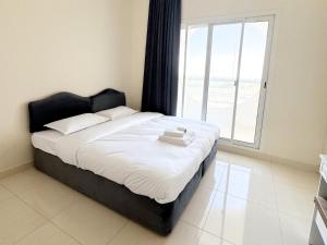 Cama en habitación con ventana grande en Lehbab Star Residence - Home Stay, en Dubái