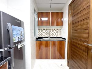 uma cozinha com um lavatório e uma porta de madeira em Lehbab Star Residence - Home Stay no Dubai