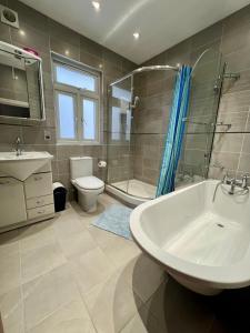 y baño con lavabo, aseo y ducha. en Saint Gabriel's Road Guesthouse, en Londres