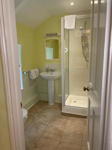 a bathroom with a shower and a sink at The Spinney in Barnstaple