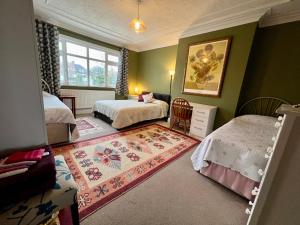 a bedroom with two beds and a rug at Saint Gabriel's Road Guesthouse in London