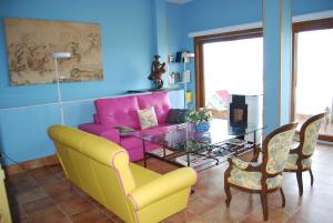 sala de estar con sofá rosa y mesa de cristal en Casa Canava, en Jimena