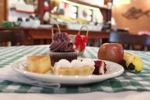 a plate with a cupcake and apples on a table at Pousada Manacas in Ubatuba